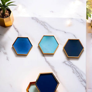 Set of hexagonal ceramic coasters by Audacem on a marble surface