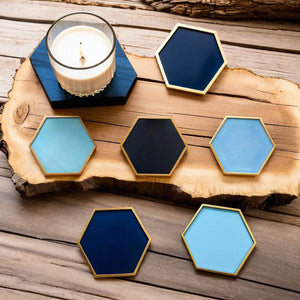 Hexagonal ceramic coasters by Audacem with a candle on a wooden board