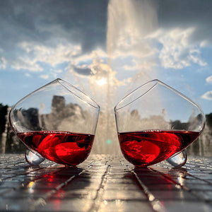 Aequilibrium wine glasses by Audacem filled with red wine in front of a fountain