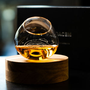 Elegant handcrafted Aequilibrium distillate glass by Audacem on coaster for whiskey, liquors, and spirits. Rotating design