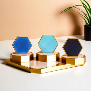 Hexagonal ceramic coasters by Audacem displayed on a golden tray