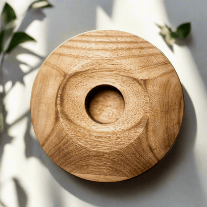 Wooden coaster with central hole on a light background